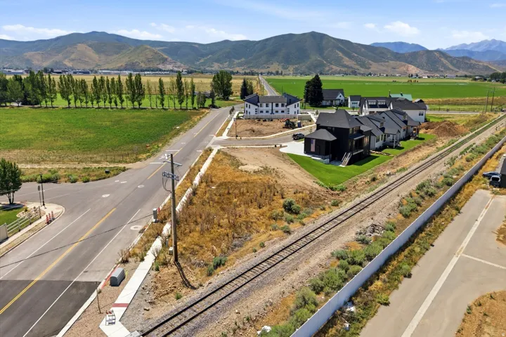 Newly constructed homes featuring contemporary architecture, dark exterior siding, and manicured lawns