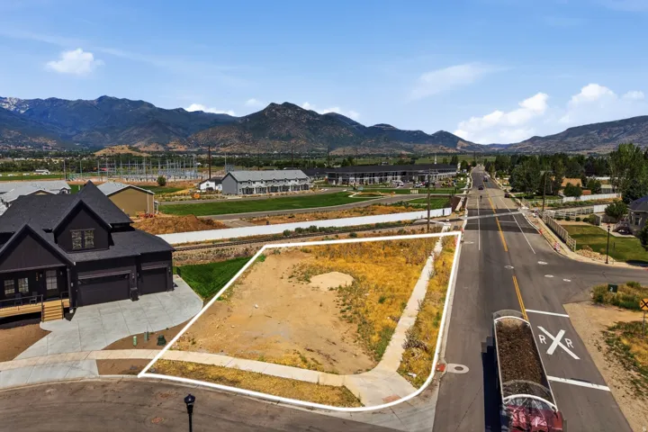 Level building lot with mountain backdrop, sidewalk access, and street frontage