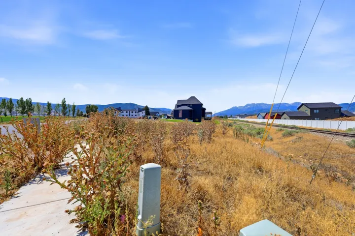 Expansive vacant land with natural sagebrush vegetation and mature landscaping