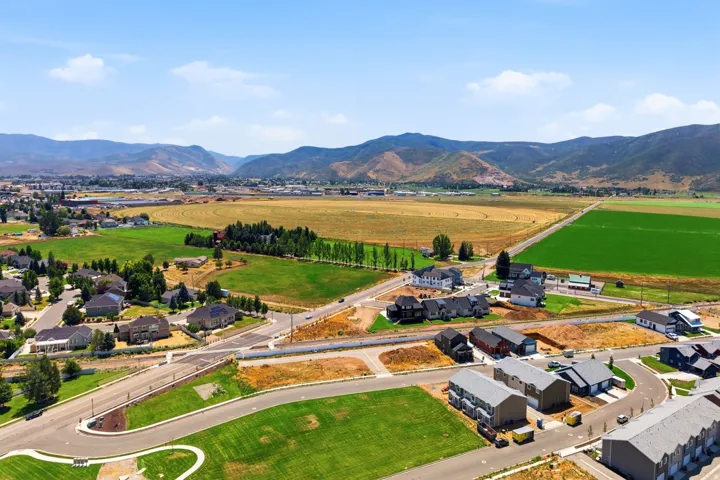 Aerial perspective showcasing a developing residential area with established homes, new construction, and vacant lots