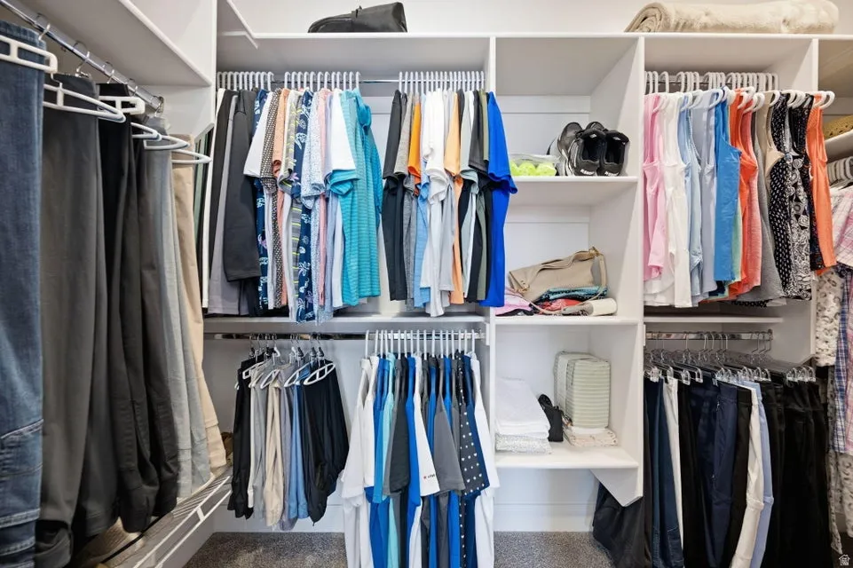 Custom closet system featuring white shelving and chrome hanging rods