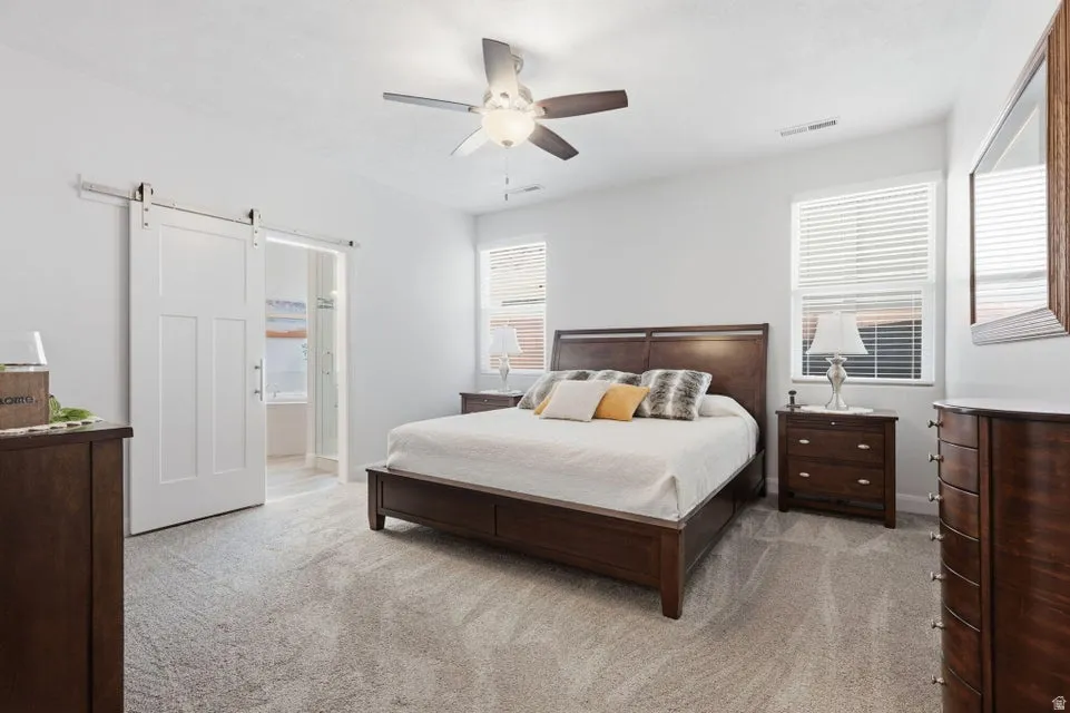 Spacious room featuring light-colored walls and plush carpeting