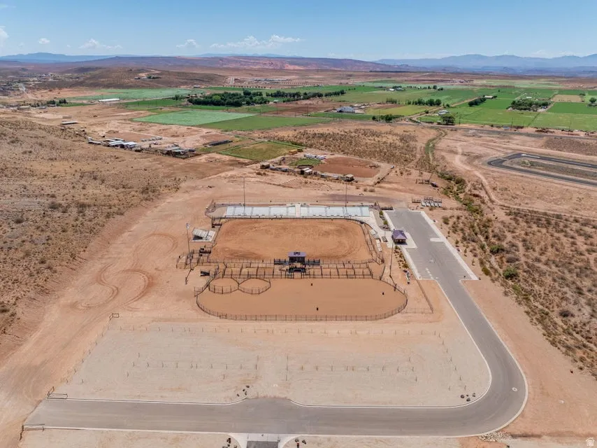 Equestrian facility featuring a large arena with spectator seating, multiple round pens, and extensive flat ground