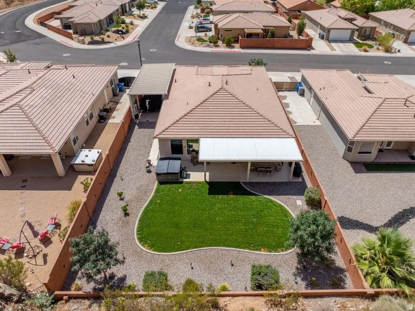 Aerial view showcasing a generously proportioned backyard featuring a lush, manicured lawn bordered by mature landscaping and established trees