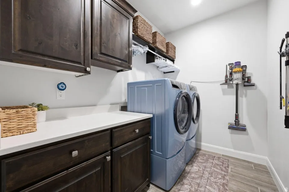 Utility room featuring dark wood-finish cabinetry, white solid-surface countertops, and wood-look tile flooring