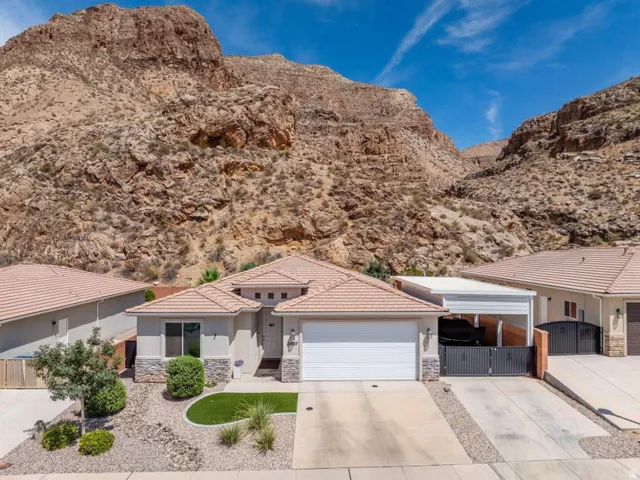 Contemporary stucco residence featuring a tiled roof and an attached garage