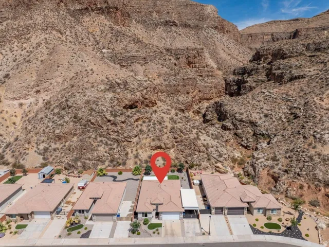Desert landscape home featuring a tile roof, paved driveway, attached garage, and xeriscaping