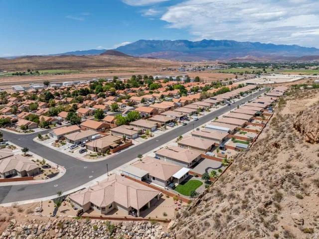 Residential development featuring a grid of single-story homes with terracotta-hued tile roofs