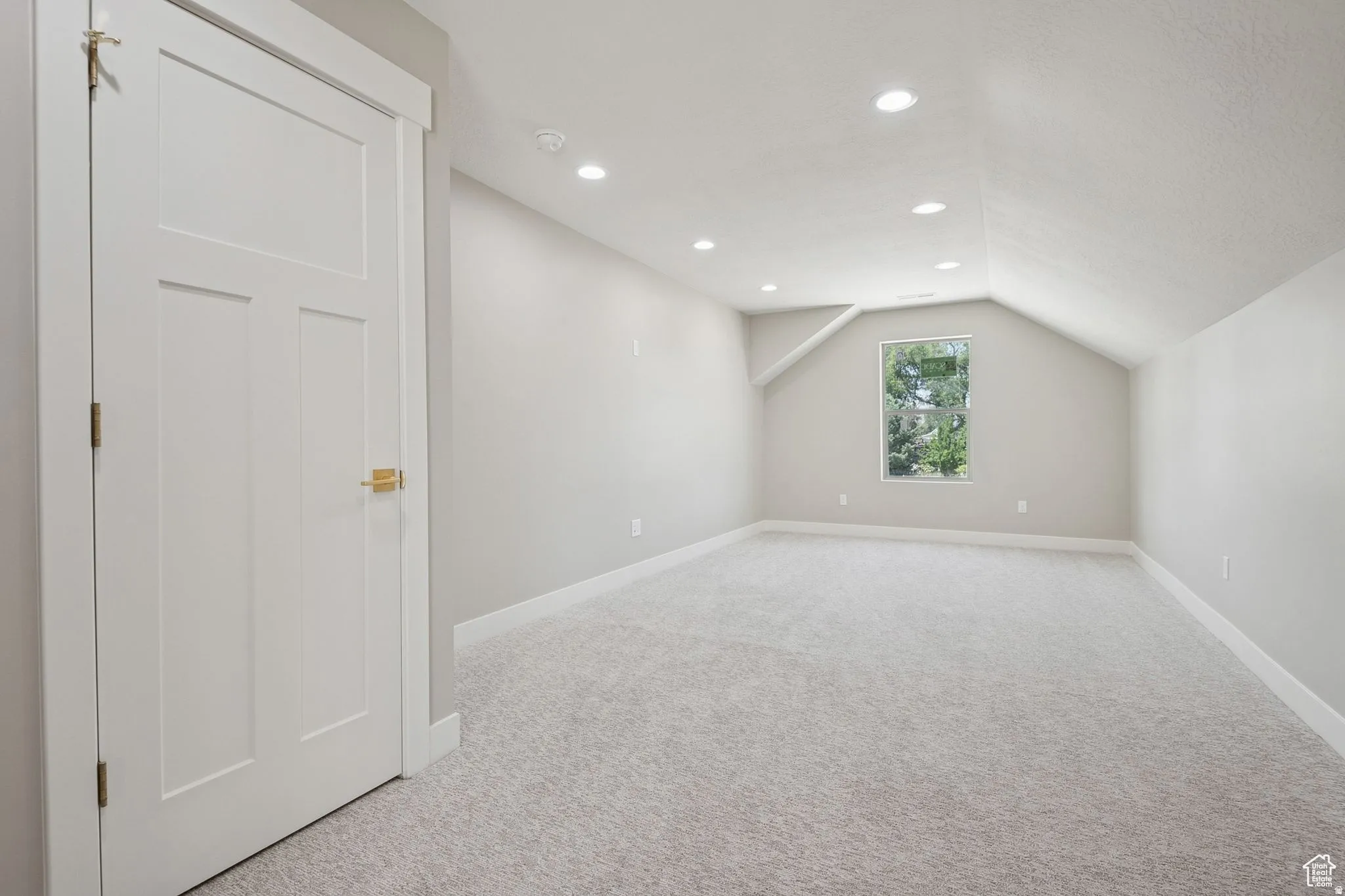 Spacious bonus room featuring pristine carpeting, recessed ceiling lighting, and abundant natural light from a fixed window