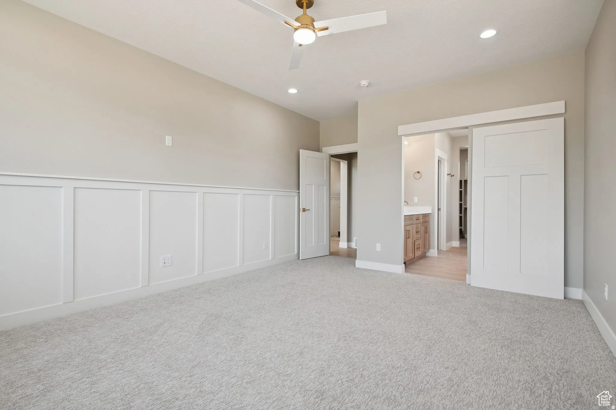 Spacious room featuring board and batten wainscoting, recessed lighting, and a ceiling fan with light fixture
