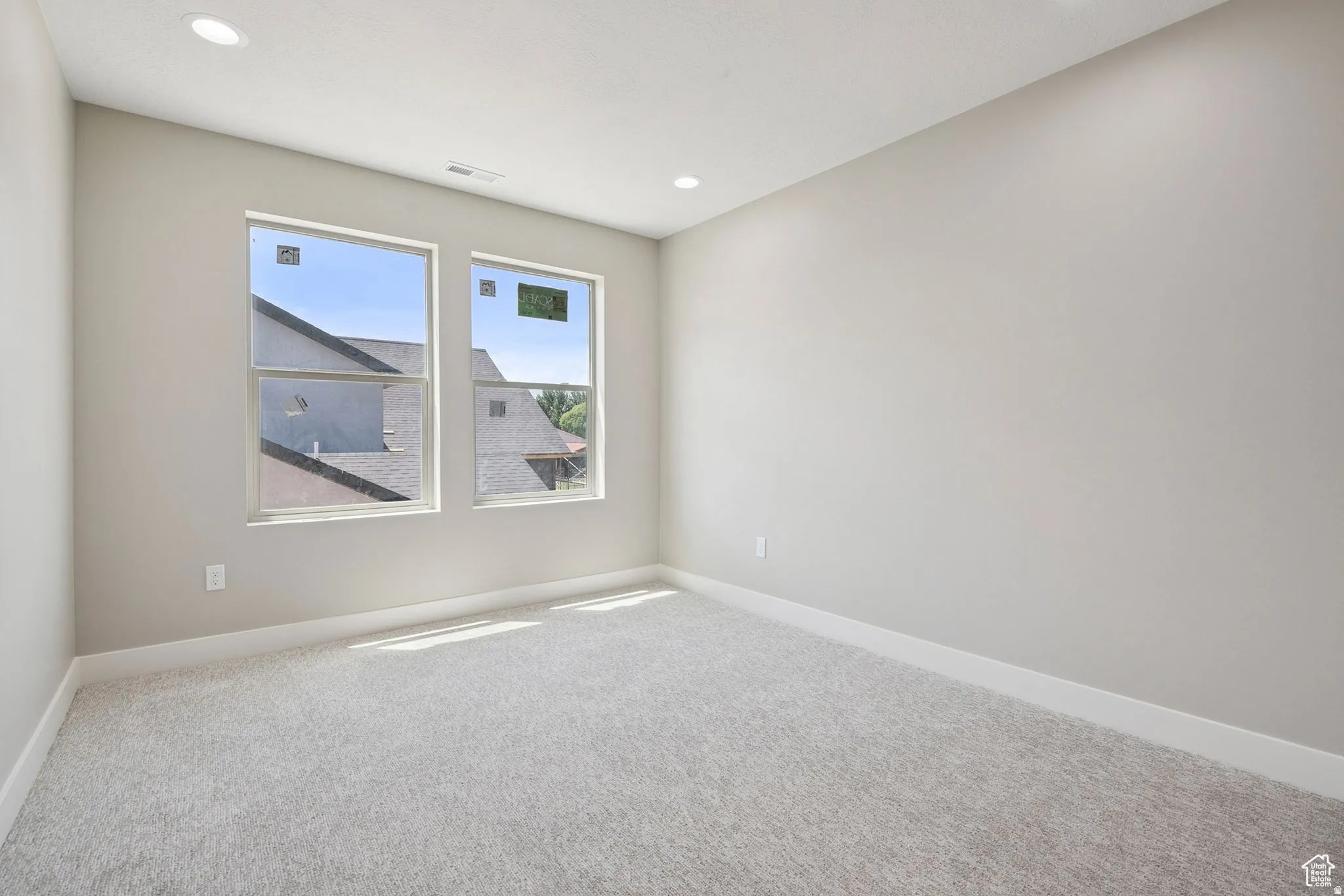 Bright and spacious bedroom flooded with natural light through dual windows