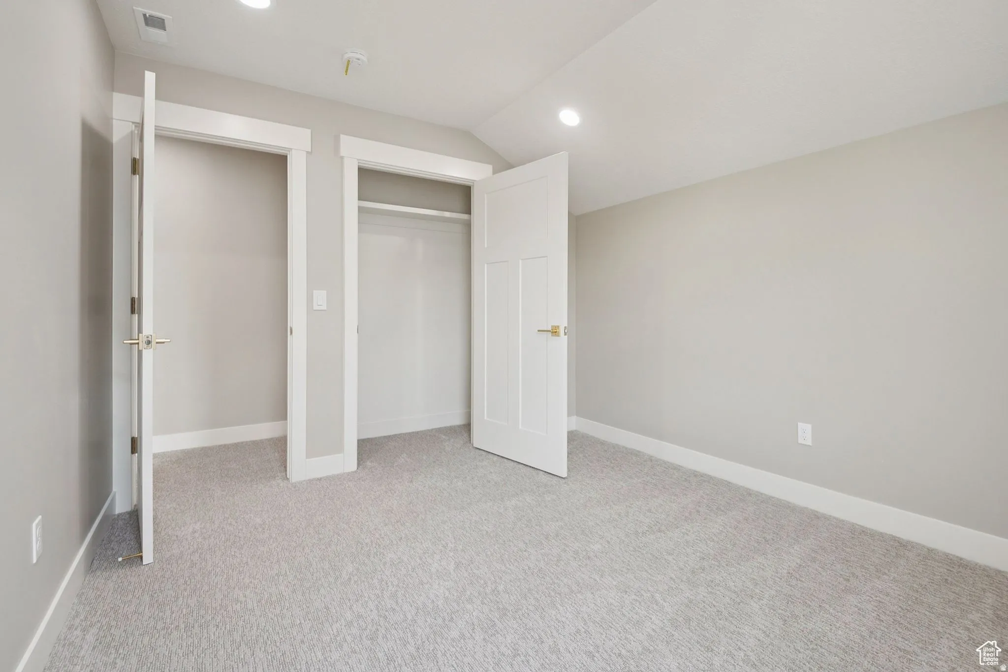 Bright interior space featuring light gray carpeting, neutral wall finishes, and white trim