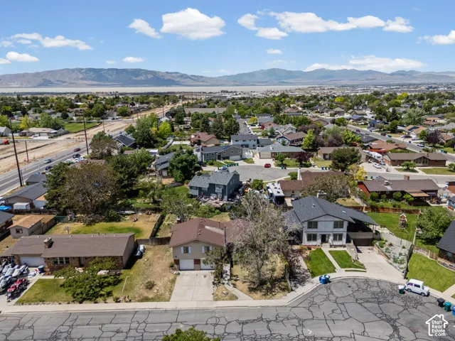 Aerial view showcasing this residential property situated on a generous corner lot with mature landscaping, established trees, and defined hardscaping