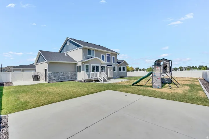 Two-story home featuring a modern farmhouse design with mixed exterior finishes including stone and siding, peaked rooflines with architectural detail, and a covered front entry