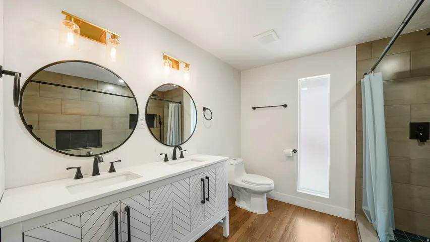 Dual vanity with white countertops and herringbone-patterned cabinetry
