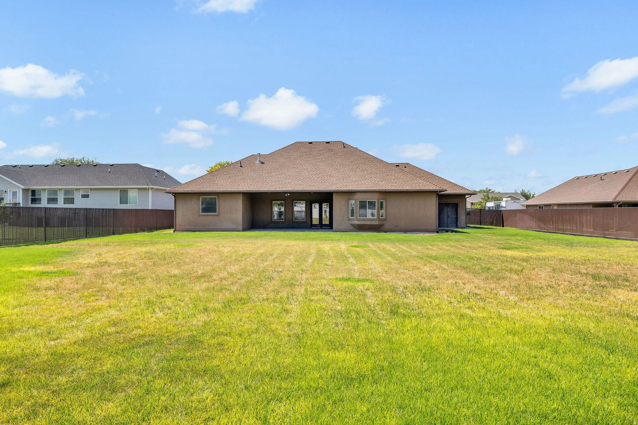 Spacious single-story residence featuring a tan stucco exterior with a distinctive hipped roof design