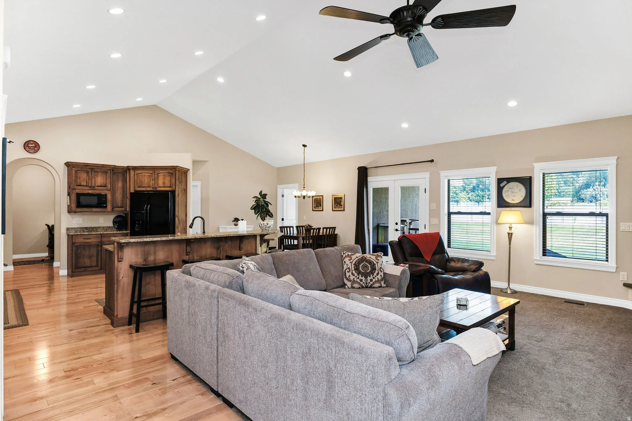 Open-concept living space featuring vaulted ceilings with recessed lighting and a ceiling fan