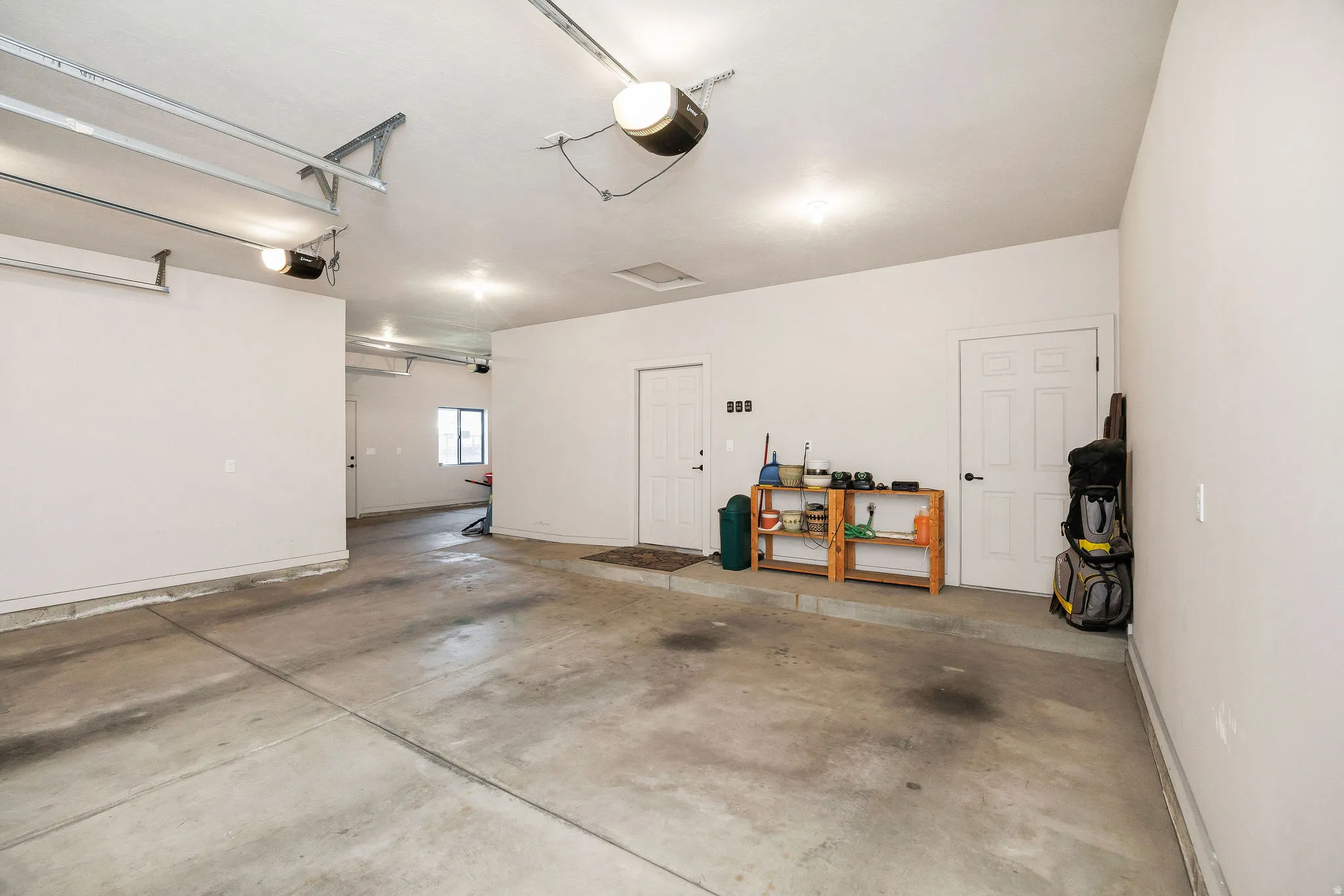 Spacious garage featuring a concrete floor, painted walls, and multiple overhead light fixtures