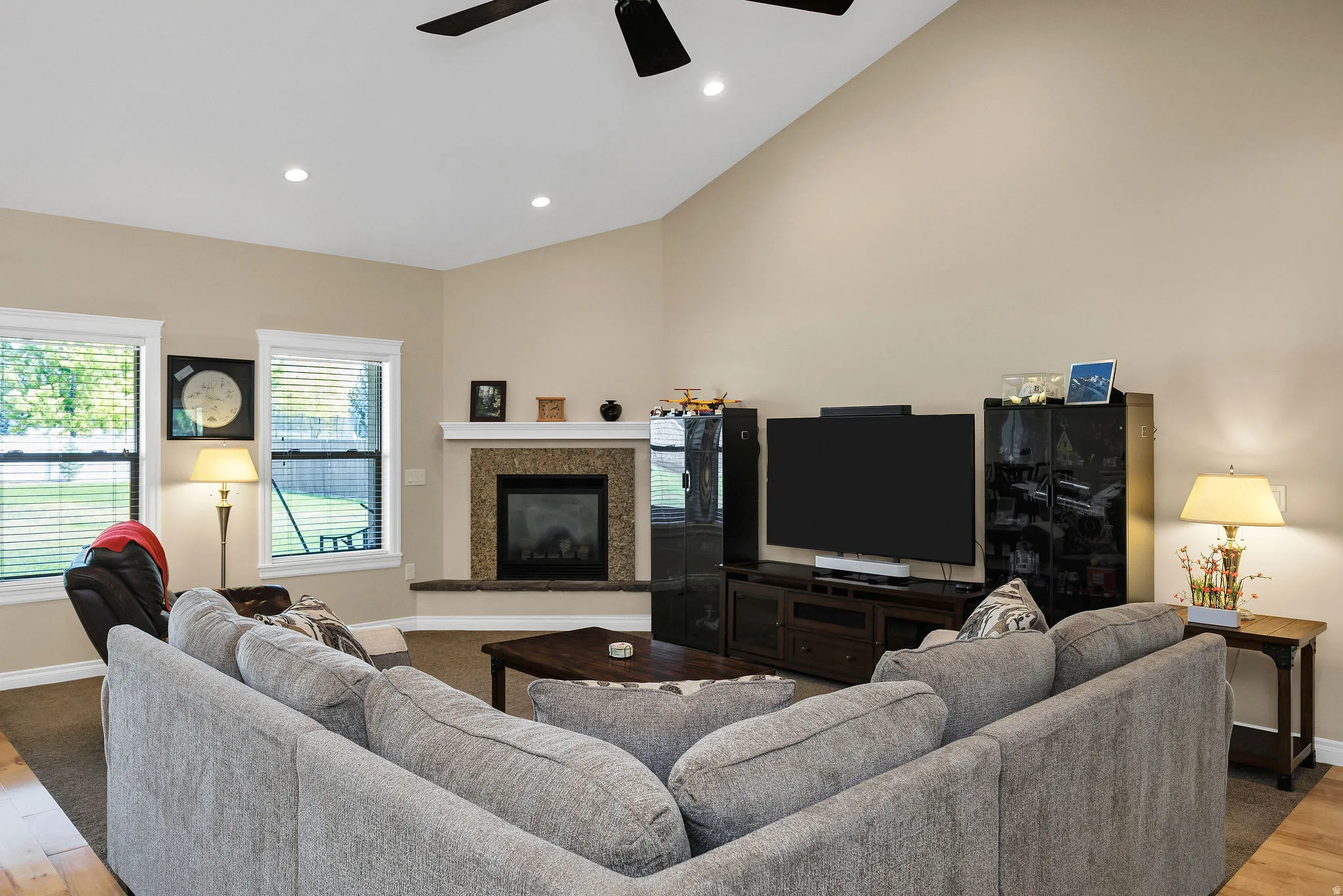 Living area featuring a vaulted ceiling with a ceiling fan and recessed lighting