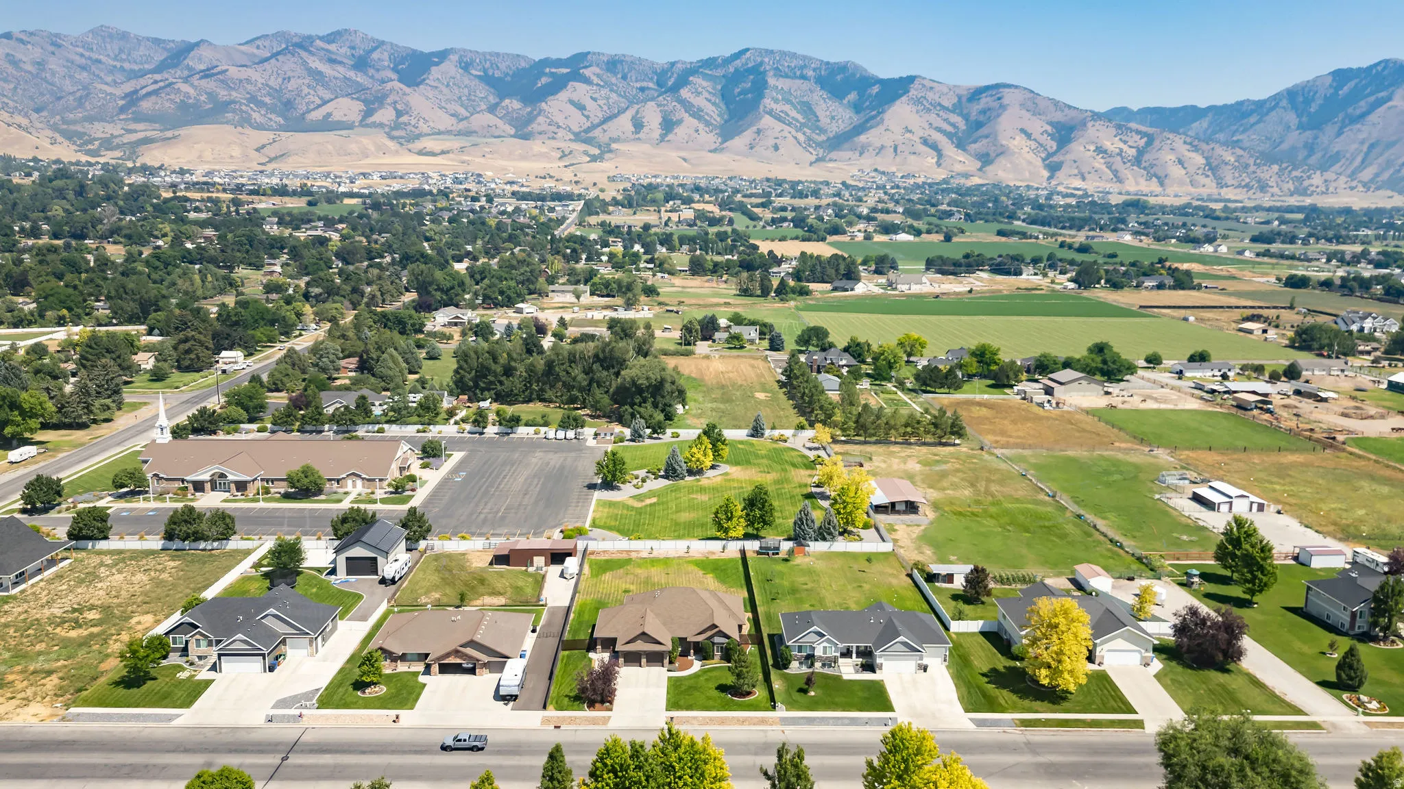 Aerial view of a newly developed residential subdivision featuring individual home lots with modern architecture, manicured lawns, and mature landscaping