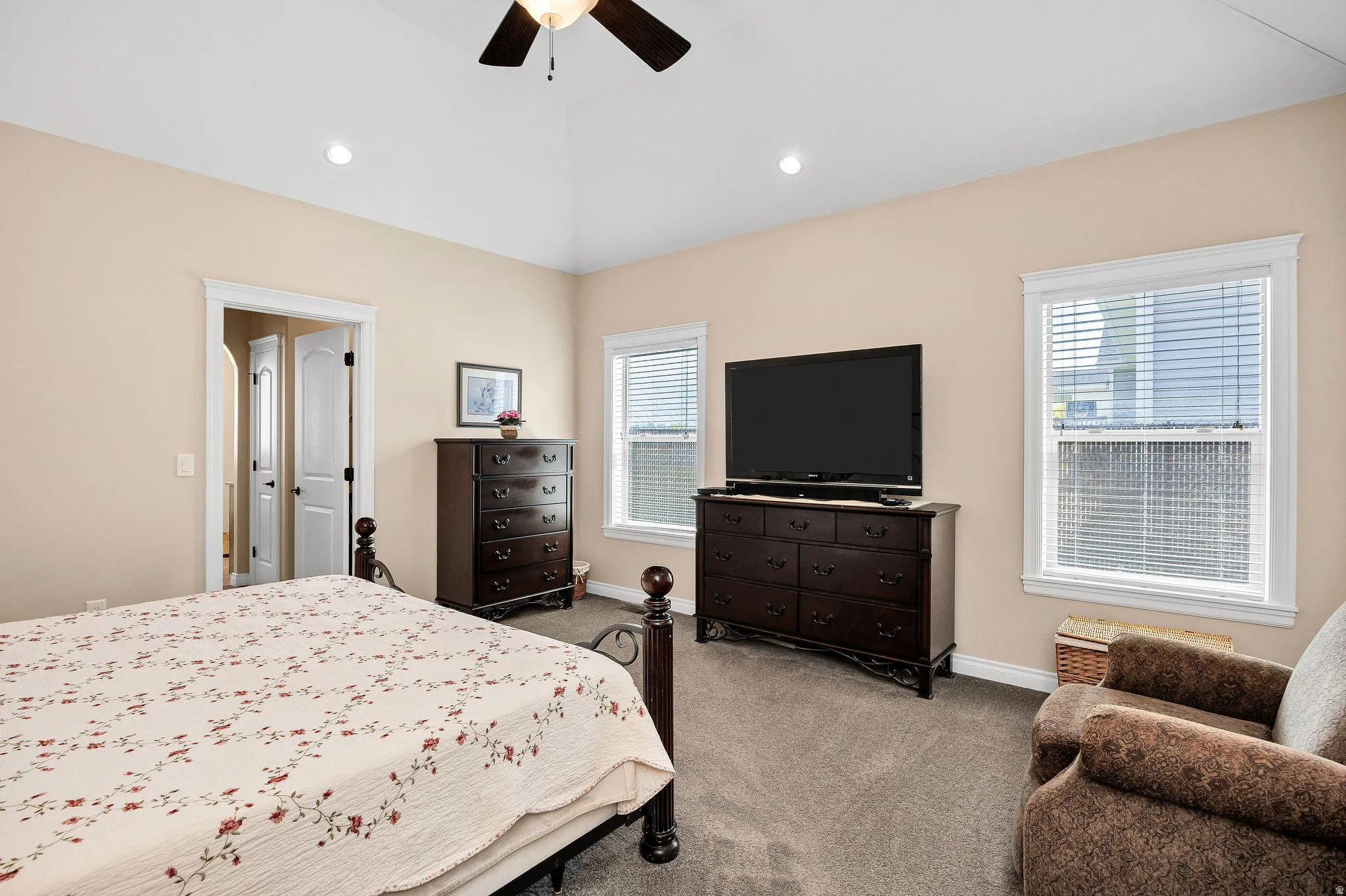 Spacious bedroom featuring neutral wall finishes, ceiling fan with recessed lighting, and carpet flooring