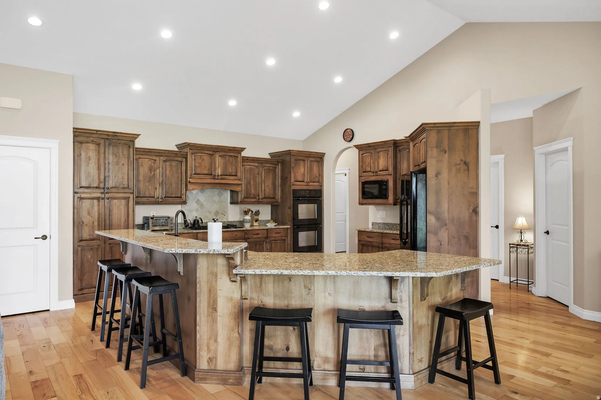 Kitchen featuring abundant wood cabinetry, granite countertops, an integrated double oven, and recessed lighting