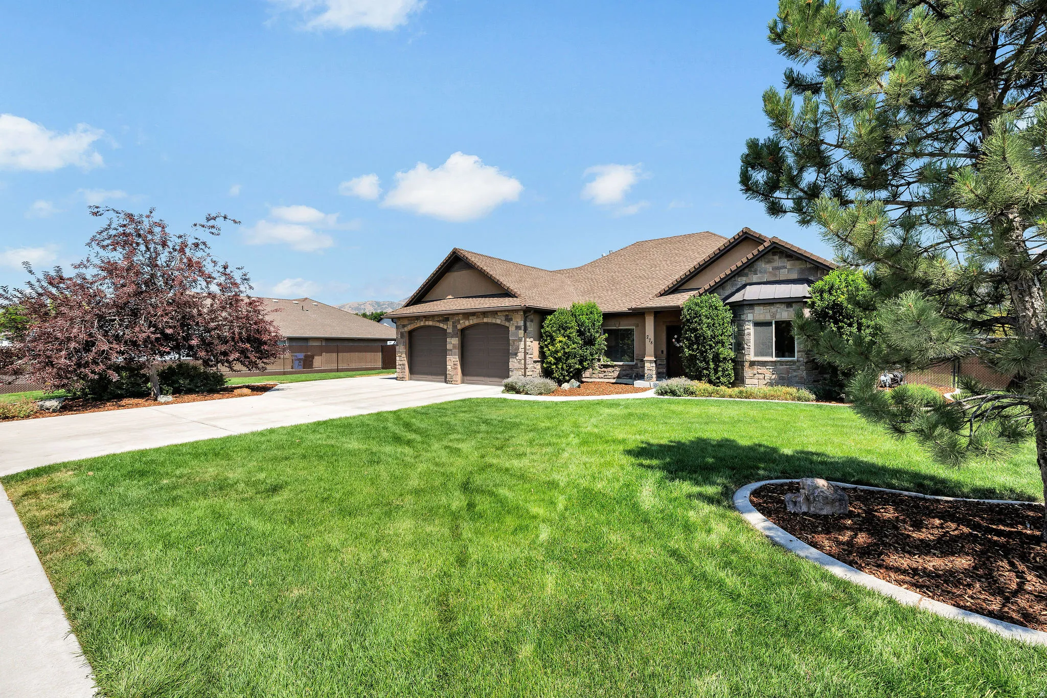 Exterior architectural design featuring stone facade accents and a two-car garage