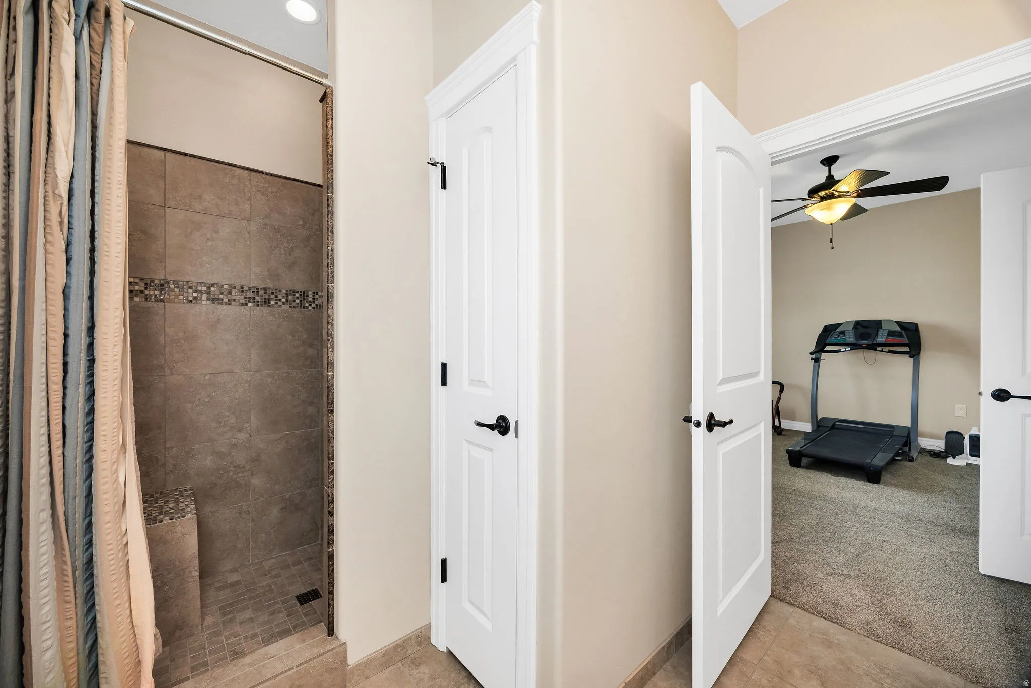 Primary Bathroom with Walk-In Shower and Spa-Inspired DesignThis spa-like bathroom features a spacious walk-in shower with tile surround and decorative mosaic accent band, complemented by neutral earth-tone finishes