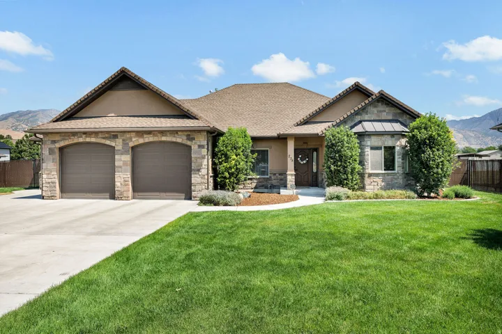 Stunning single-story residence showcasing a stone and stucco exterior with a prominent two-car garage