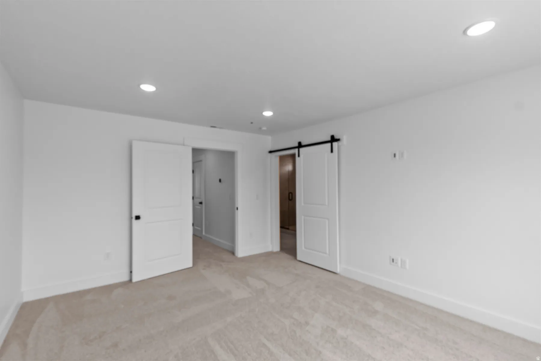 Spacious room featuring neutral carpeting and white walls