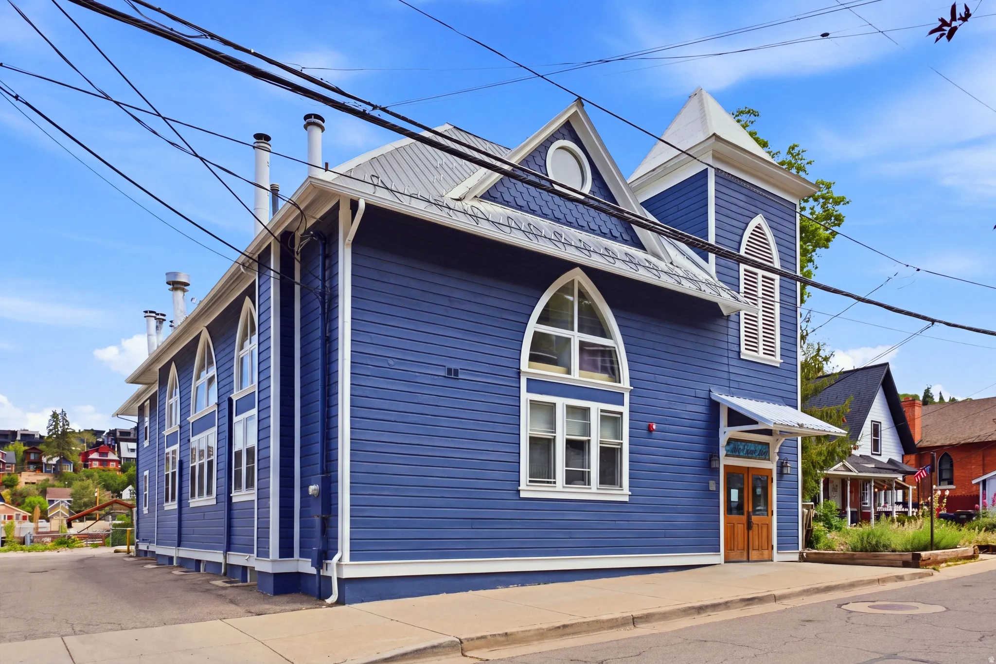 Blue horizontal siding exterior with a pitched metal roof