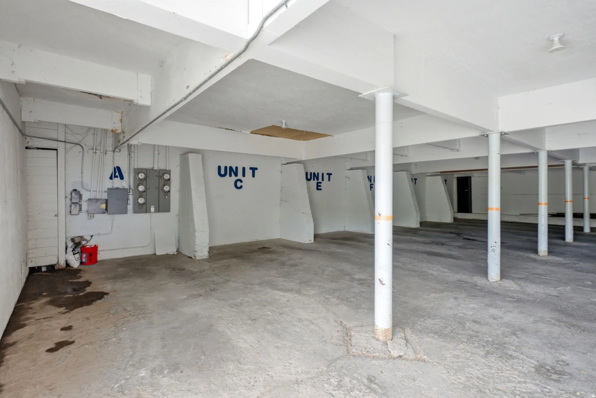 Open garage with concrete flooring and multiple structural support pillars