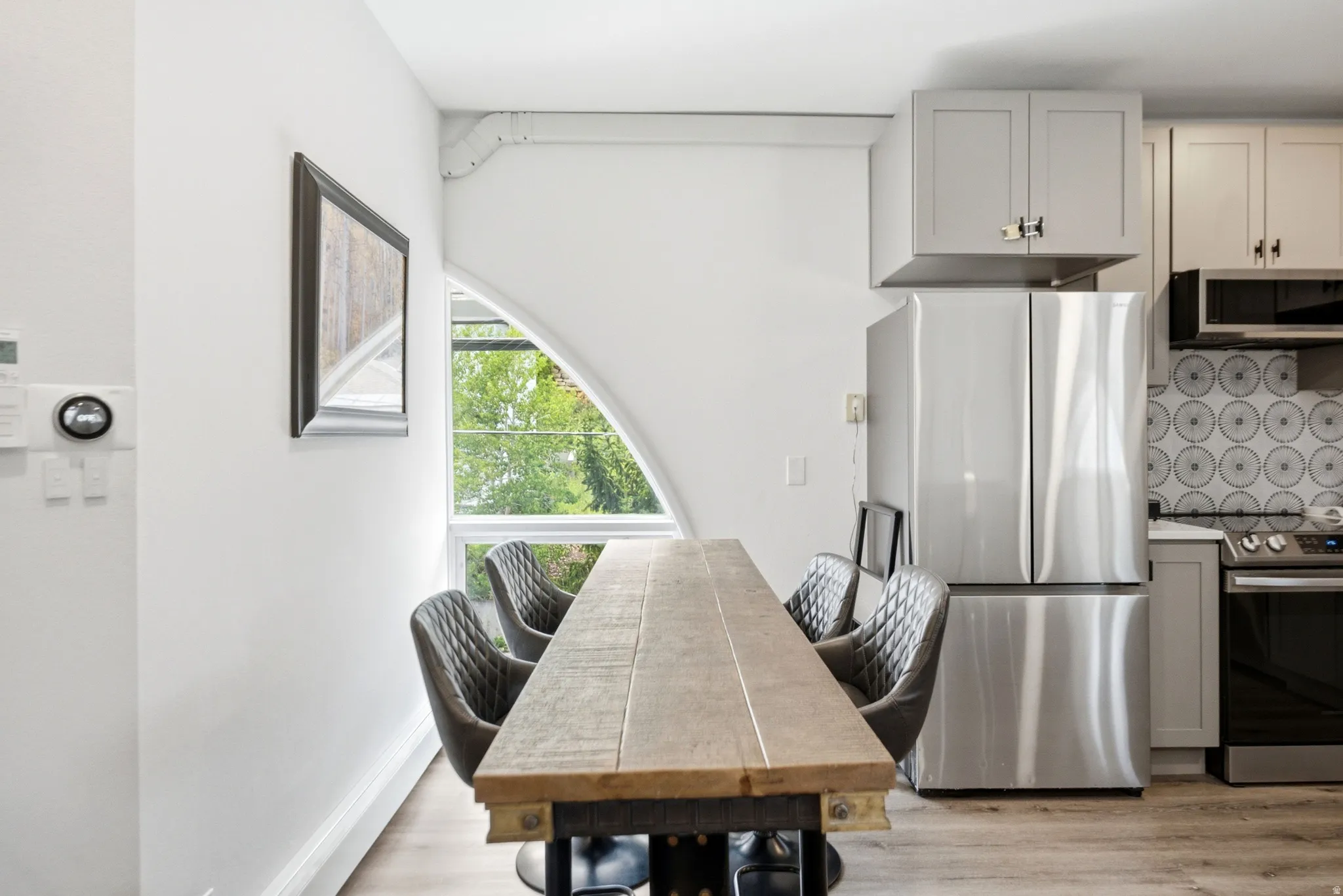 Modern kitchen and dining area featuring light wood-finish flooring