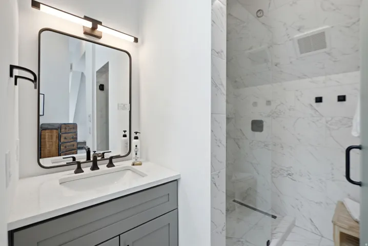 Bathroom featuring a single vanity with a gray cabinet, white countertop, and rectangular undermount sink