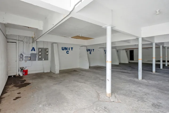Open garage with concrete flooring and multiple structural support pillars