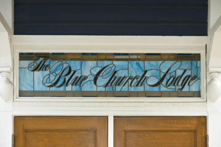 Stained glass transom window over double wood doors