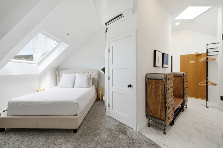 Vaulted white ceiling with skylight and recessed lighting