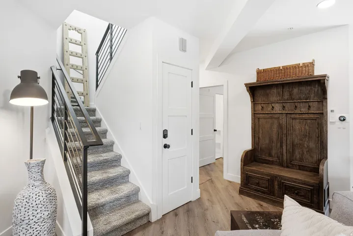 Modern staircase featuring metal railings and carpeted treads