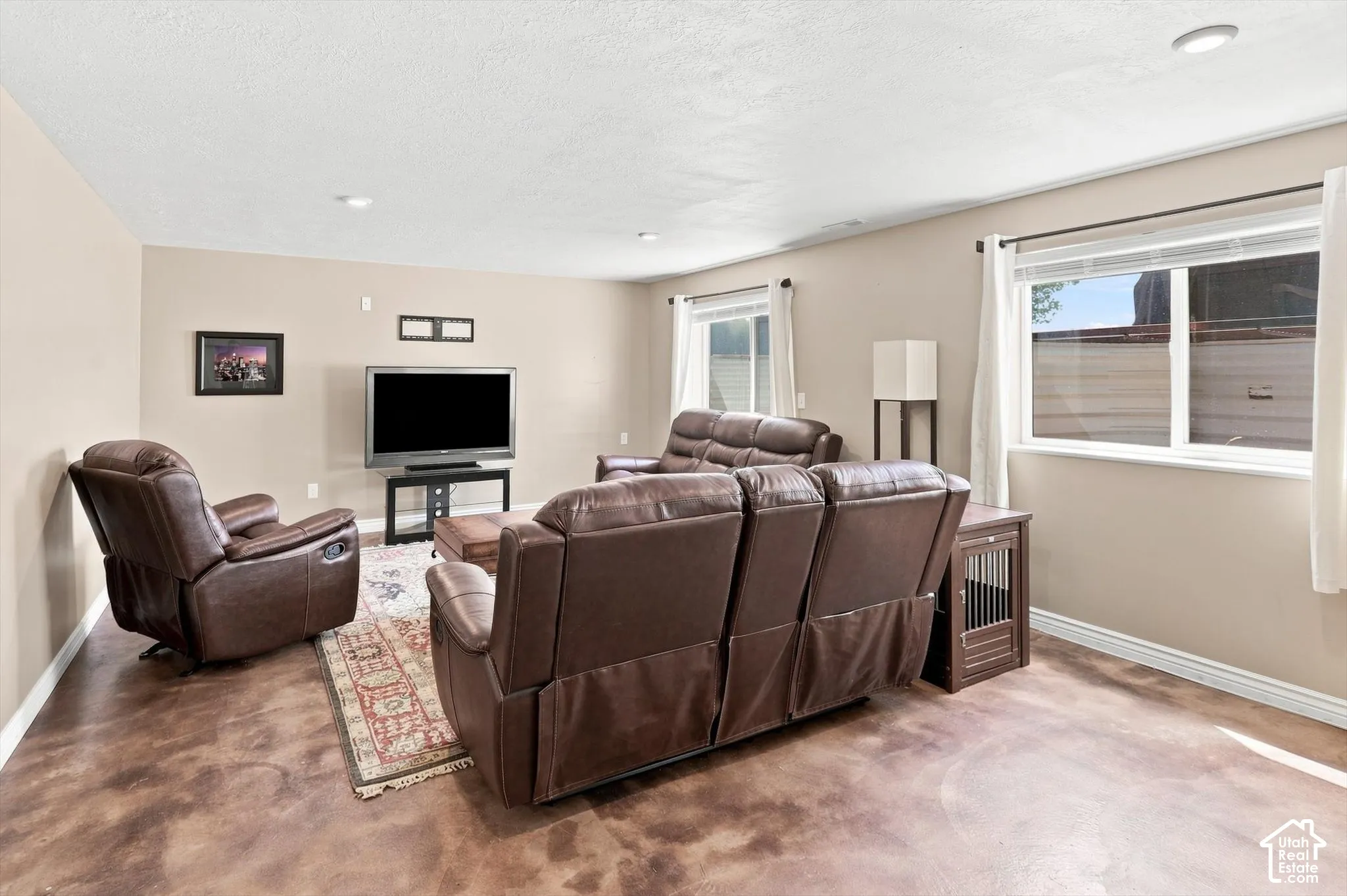 One side of spacious entertaining area / family room with stained concrete flooring