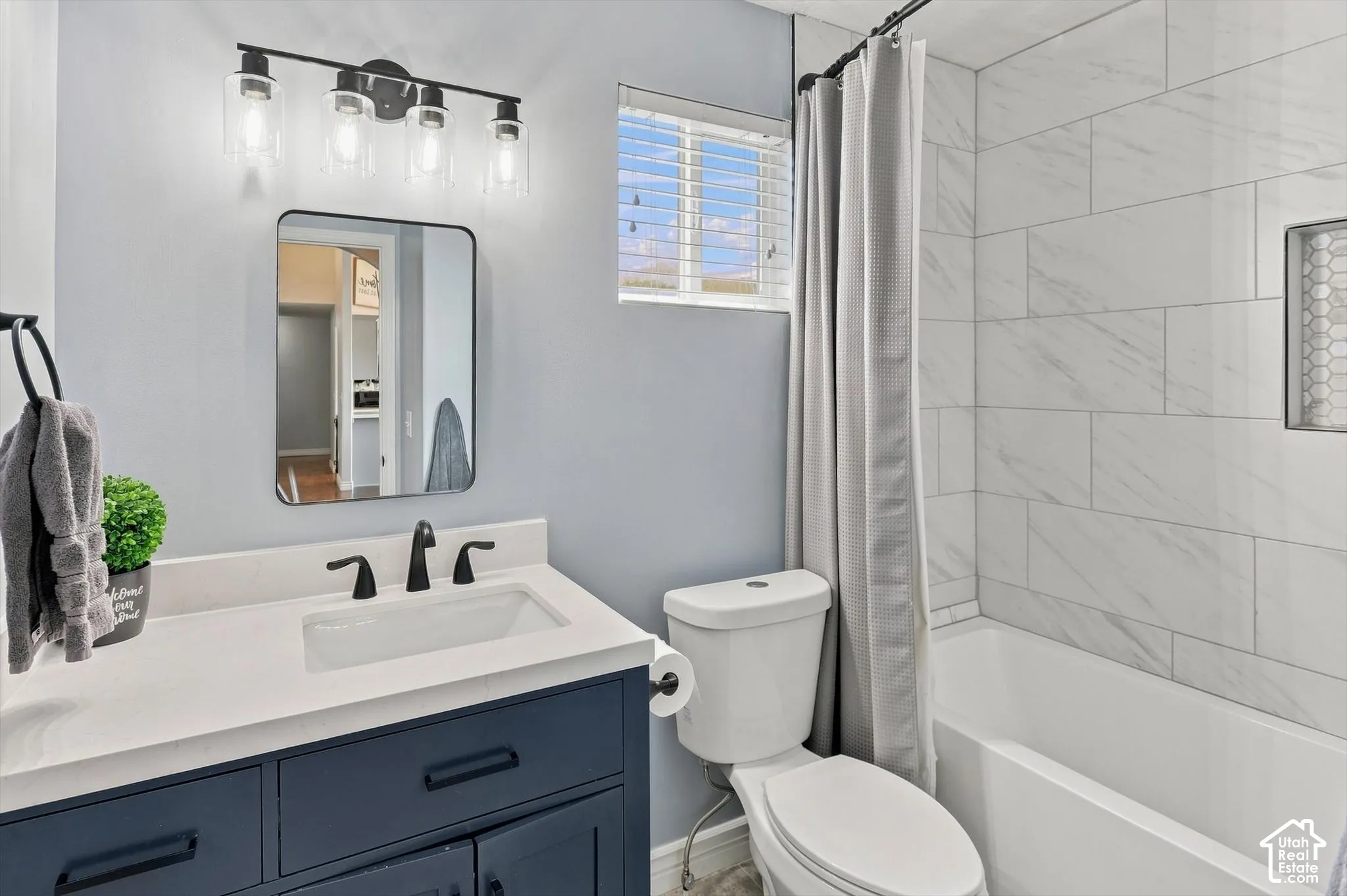 Modern bathroom featuring a tiled shower/bath combo, new cabinetry and sink