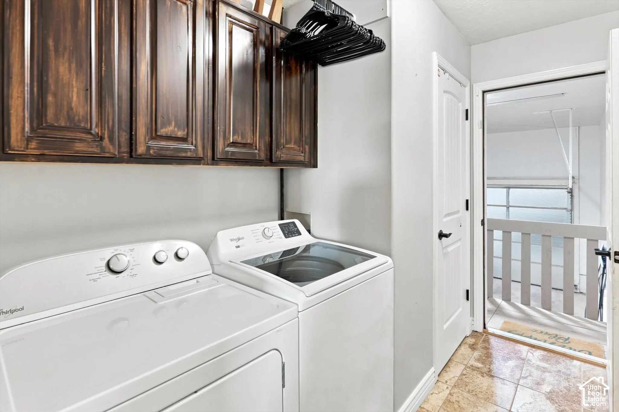 Dedicated laundry room off garage with rich wood cabinetry and closet