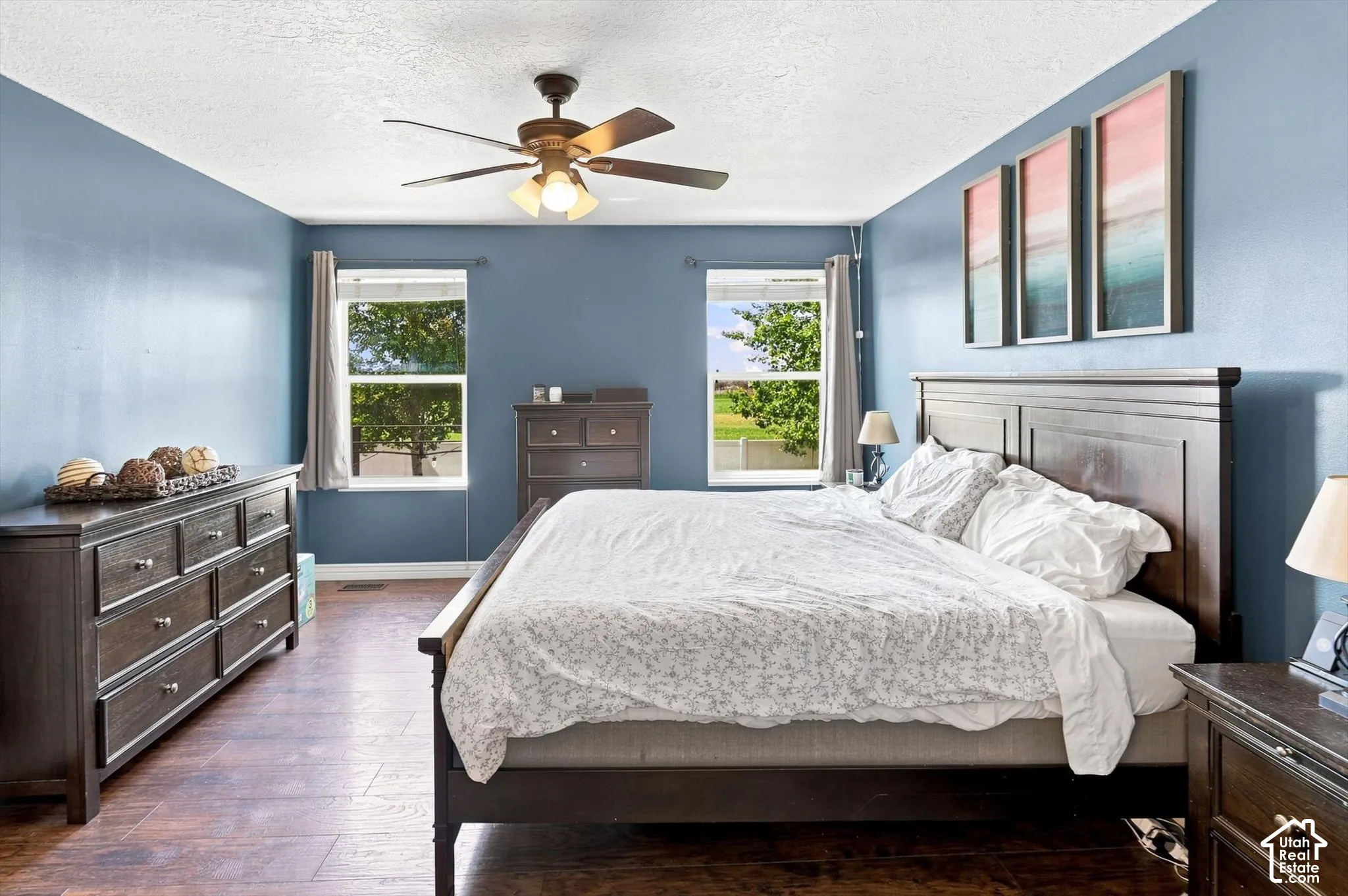 Primary bedroom with ceiling fan and windows