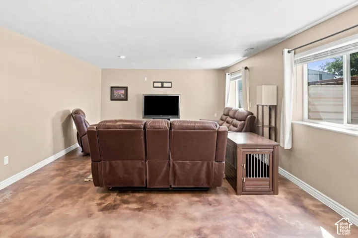 Spacious interior room featuring concrete flooring and neutral-toned walls