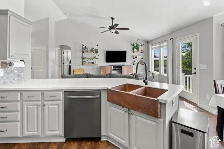 Kitchen island bar featuring a double-basin copper farmhouse sink with a matte black faucet, integrated stainless steel dishwasher, and light gray cabinetry with white countertops
