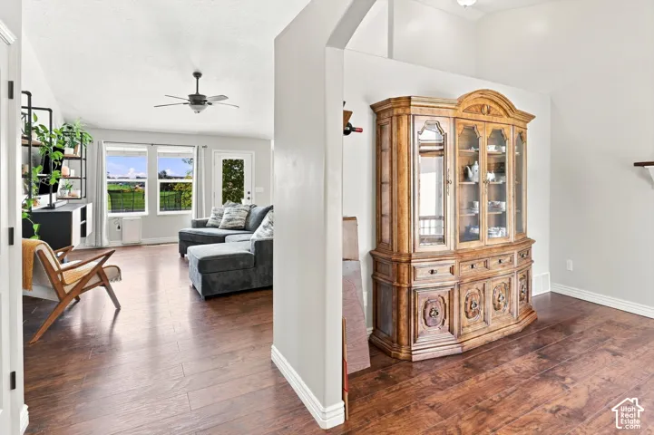 Open-concept living area featuring LVP flooring, soaring vaulted ceilings with recessed lighting, and abundant natural light from multi-pane windows
