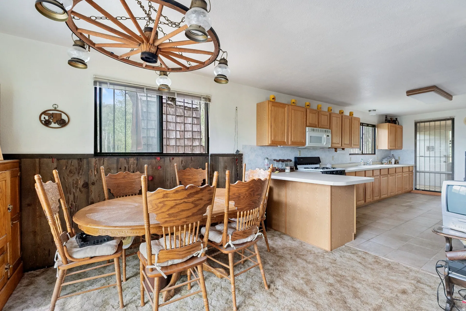 Open-concept kitchen and dining area featuring natural wood cabinetry and a central island