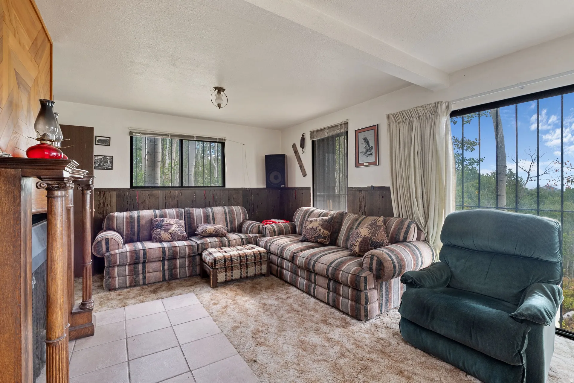 Room featuring a wood-panel accent wall and a classic fireplace mantel