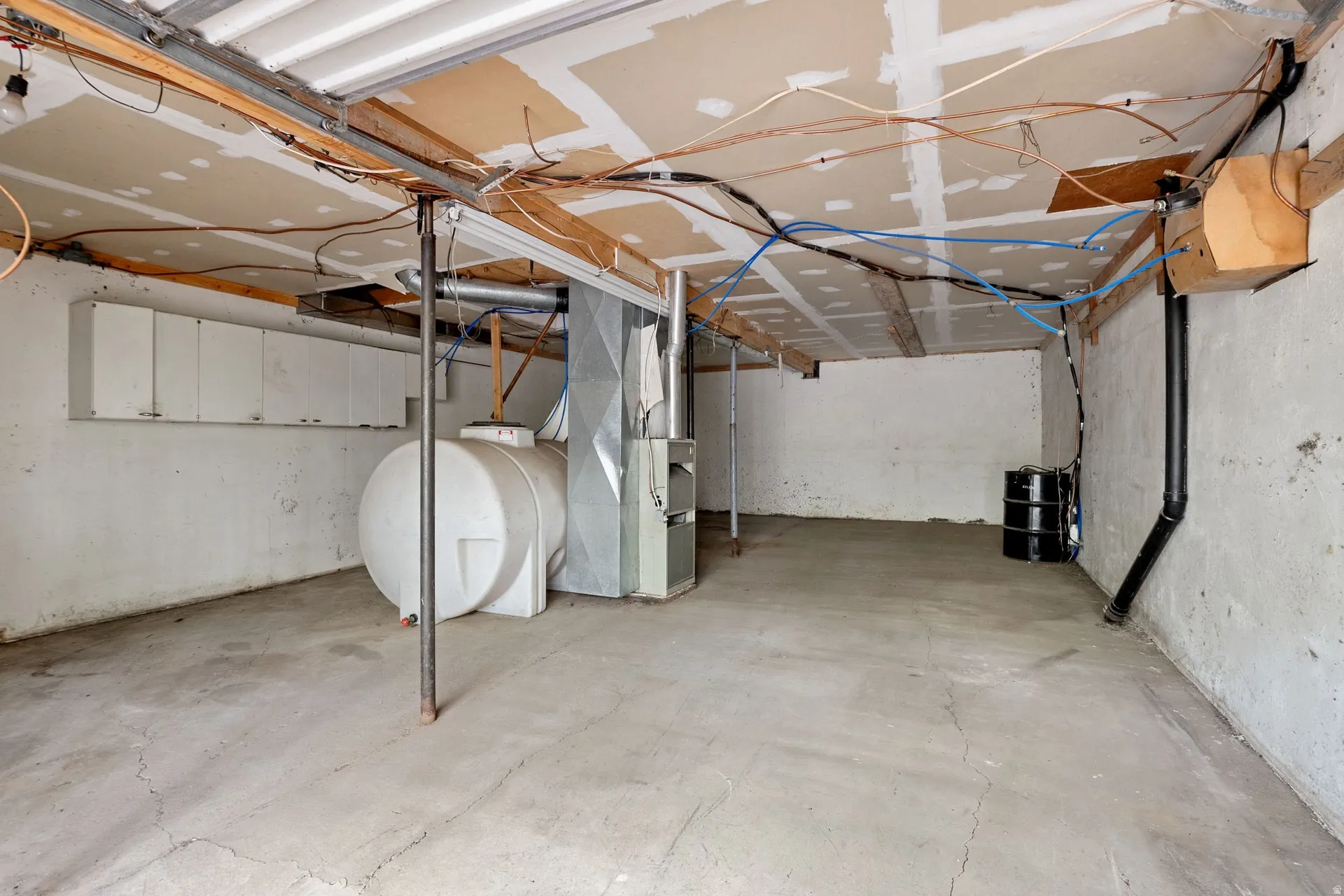 Concrete floor with exposed ceiling joists and utility lines