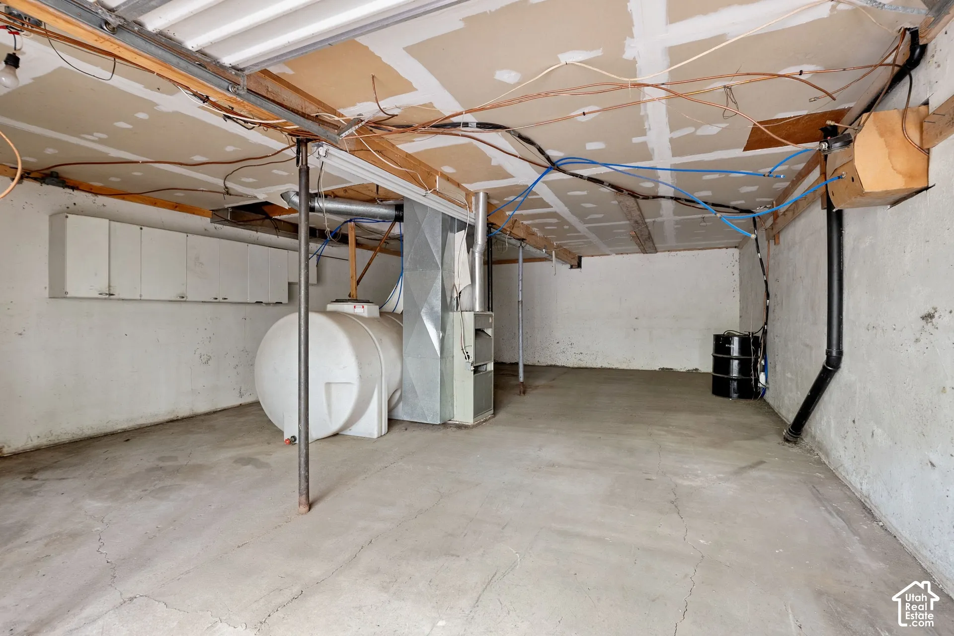 Concrete floor with exposed ceiling joists and utility lines
