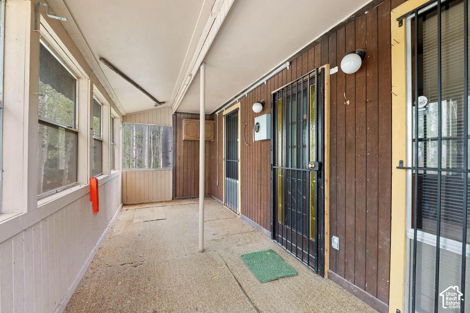 Screened porch with concrete flooring and wood-paneled walls